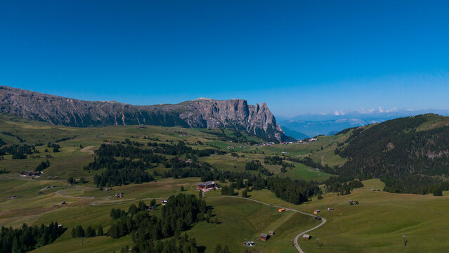 View of beautiful landscape in the Alps with fresh green meadows in the background on a sunny day with blue sky and clouds in summertime. Alpe de Siusi, Dolomite Alps
