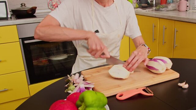 Woman preparing vegetables for family meal in home kitchen. Close-up of hands slicing eggplant during everyday cooking