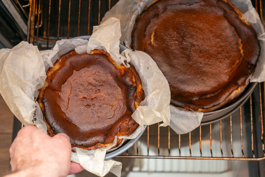 Freshly baked chocolate dessert cooling in a round springform cake pan lined with crumpled parchment paper. The rich, dark baked surface resembles a flourless chocolate cake or burnt Basque-style cake