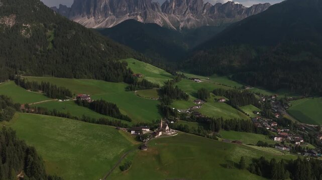 serene mountain landscape observed from aerial view in rural mountainous area with green hills and village in the distance, nature travel destination with peaceful and vibrant greenery.