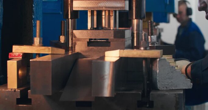 Industrial metal stamping on mechanical press. Close-up of working die during metal component production