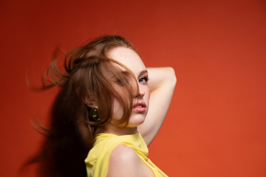 Woman in a yellow dress with windswept hair 