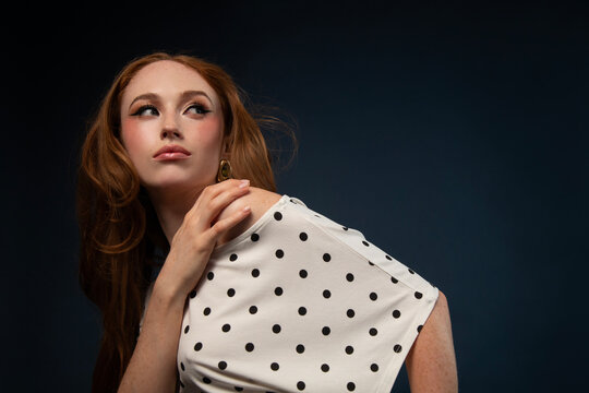 Studio portrait of a woman in a polka dot top with windswept hair