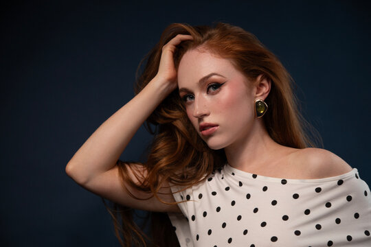 Studio portrait of a woman in a polka dot top with windswept hair