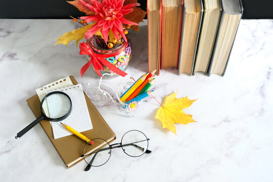 school supplies, autumnal leaves, eyeglass, loupe and books on table. Education, Knowledge Day, back to school, Teacher's day holiday concept. greeting card design. top view