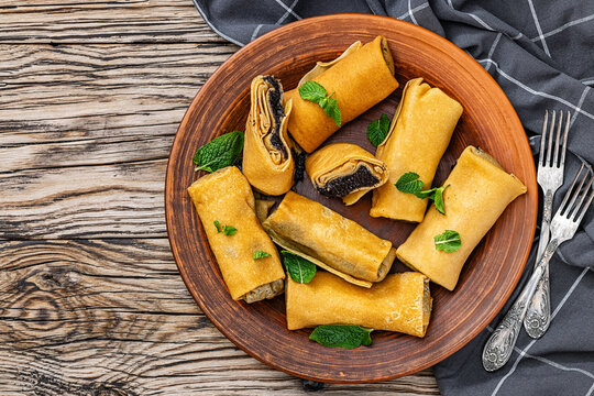 Rolled pancakes with poppy seed filling on plate