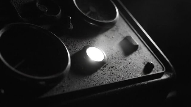 Close-up of old instrumentation with glowing light, industrial, retro, steam engine panel, black and white.