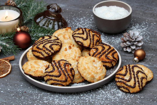  Leckere Kokosmakronen mit Schokoladenglasur auf festlich dekoriertem Weihnachtstisch.