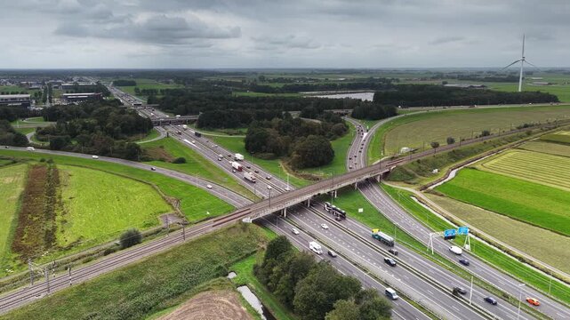 Traffic at a highway junction near Zwolle where the A28 and the A50 highways cross with a railroadbridge in the foreground in Overijssel The Netherlands.