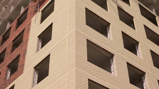 Brick facade of multistory residential building under construction