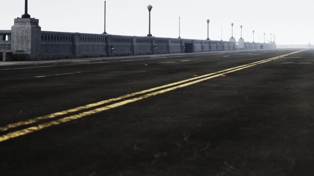 A long, empty road stretches ahead, bordered by a striking stone bridge. A thick fog blankets the area, creating an eerie, quiet atmosphere. Street lamps stand silent in the mist.