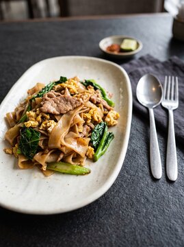 Pad see ew stir fried wide rice noodles with vegetables on a plate