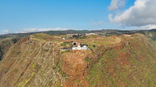 Ponta do Pargo lighthouse and clifftop, Madeira, Portugal. Aerial footage of coastal landmark with access road through short tunnel