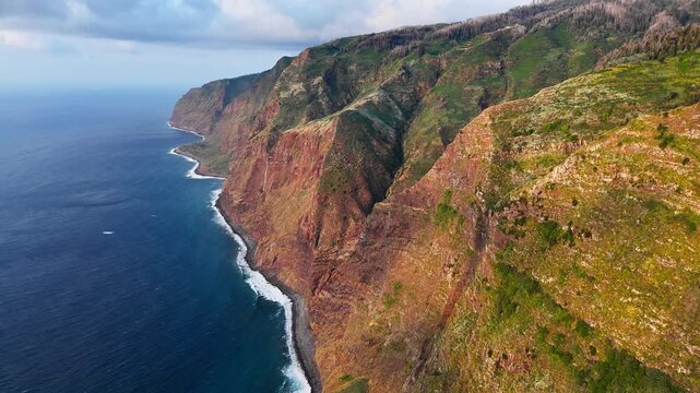 Coastal cliffs of Madeira above Atlantic Ocean, Portugal. Aerial footage of rugged headlands and secluded shoreline