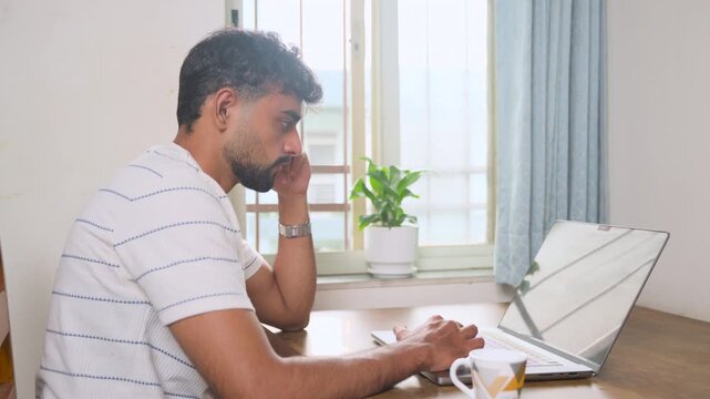 Young entrepreneur working attentively on a laptop at home. Suitable for entrepreneurship, business, remote work, freelancing, productivity and professional lifestyle concepts.