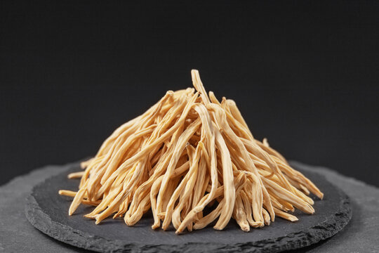 dried safed musli tuberous roots on a black slate stone tray