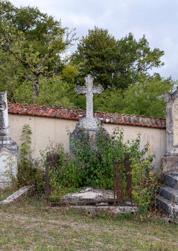 Overgrown grave with weathered stone cross, Saint-Aubin-Ch&acirc;teau-Neuf, France