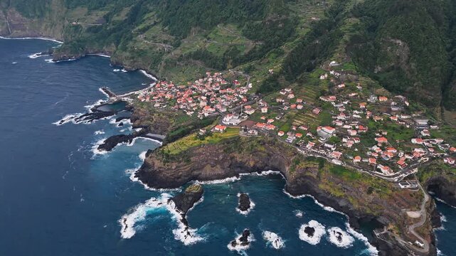 Seixal village on coastal headlands in Madeira, Portugal, aerial view. Rural settlement above volcanic cliffs beside Atlantic Ocean
