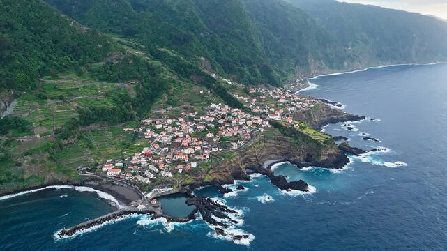 Seixal village and volcanic headlands in Madeira, Portugal, aerial view. Settlement and farmland between steep mountain slopes and Atlantic coast