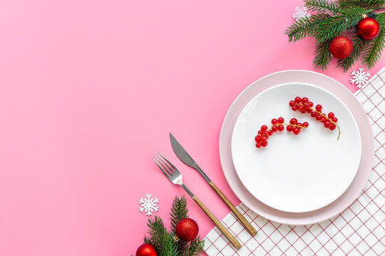 Empty plate with fir tree branch and red colored decoration. Table setting top view