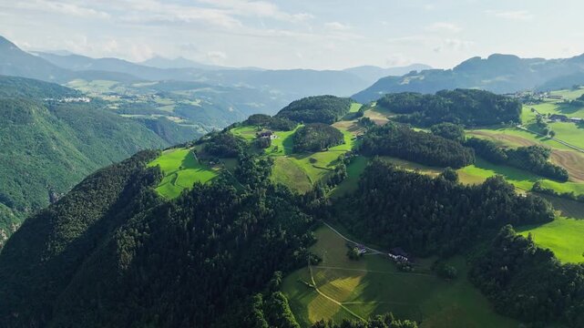 Rural South Tyrol, aerial footage of green meadows, woodland and scattered farms. Alpine countryside for holidays in nature and peaceful country escapes