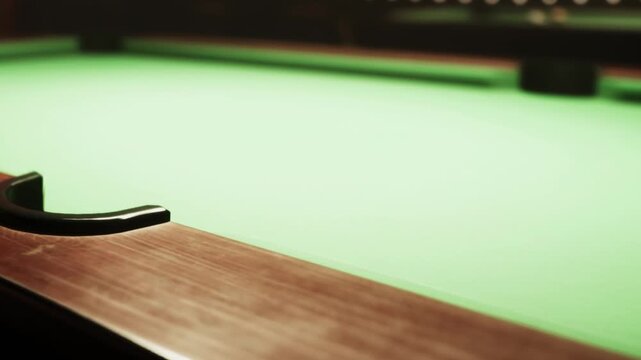 A close up of a billiard table with a rich wooden edge and vibrant green felt under soft lighting. The atmosphere feels inviting as players anticipate their turn for a game.