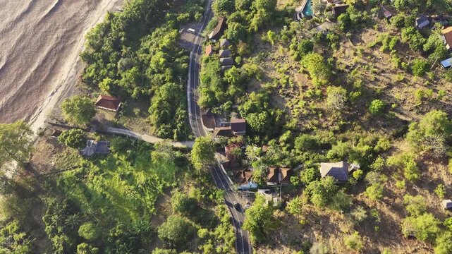 Aerial top view of bali coastal road and village