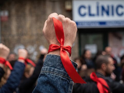 Raised fist tied with red ribbon during protest march for HIV and AIDS awareness movement