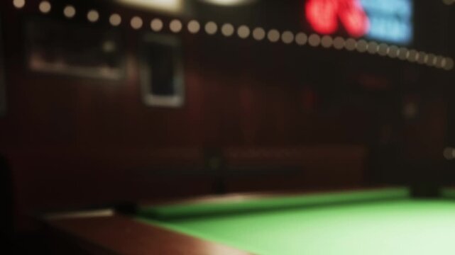 Players gather in a lively pool hall where a green felt table awaits the next challenge. The warm lighting creates an inviting ambiance, perfect for friendly matches and fun.