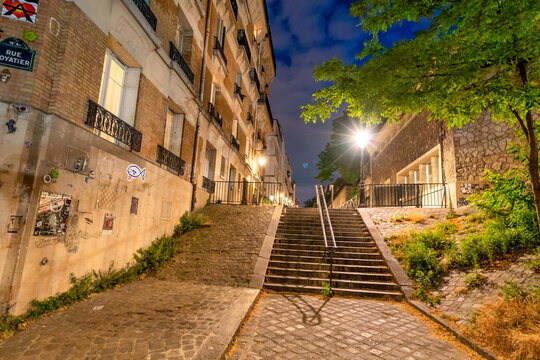 Dramatic illuminated staircase in Montmartre district at night.