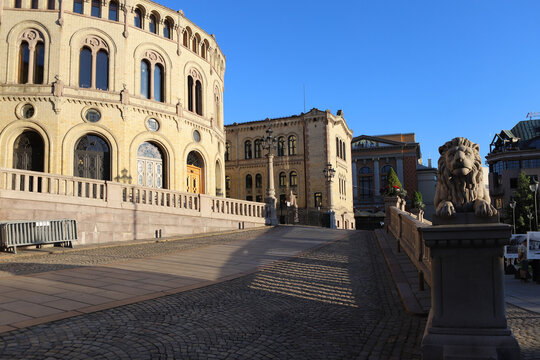 Granite lion statue guarding the entrance to the Storting parliament building in Oslo, Norway. Cobblestone street leading to the majestic Stortinget building in the capital of Norway.