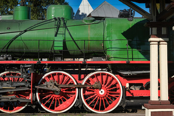 Old steam locomotive wheels. Retro steam train. A fragment of the mechanism of an old coal-fired boiler of a steam locomotive with valves. Locomotive depot, railway in the city. © VLAD ANTONOV