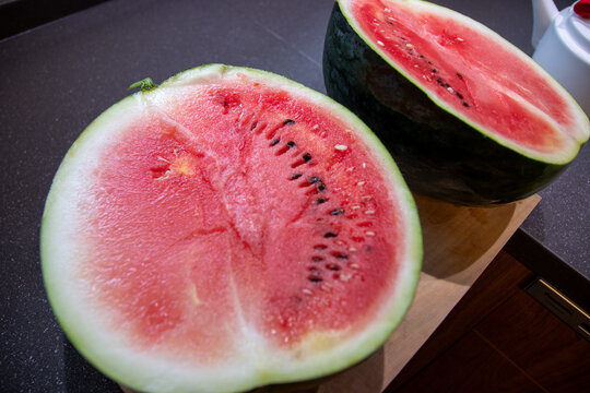Watermelon cut into triangular wedges on wooden board