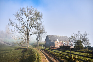 Obraz premium Village with path, house and trees in mountains.