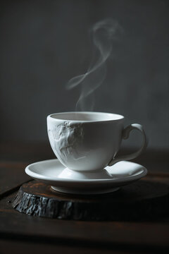 teacup with steam swirling gently against dark background