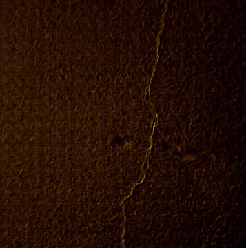 Dark brown tree bark texture displays a vertical crack and rough surface