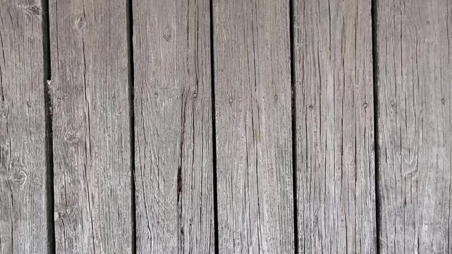 A close-up look at rustic, weathered wooden deck planks, showcasing natural textures and grains ideal for backgrounds, architectural details, or design projects.