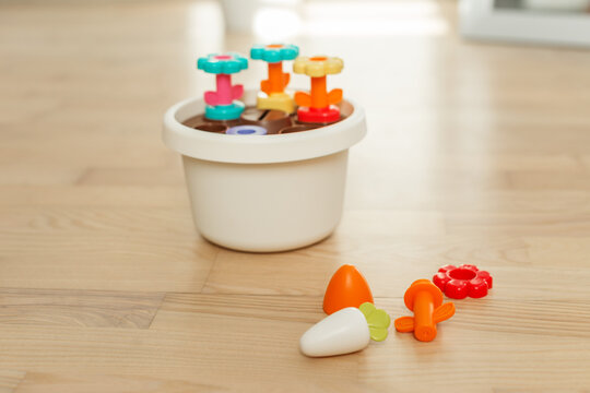 Colorful shape sorter toy with flower pieces on wooden floor