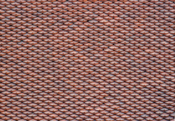 Background of traditional texture of ceramic roof tiles in asia. Reddish-brown ceramic small elements shaped like fish scales or fans, tightly arranged in rows. © Вера Тихонова