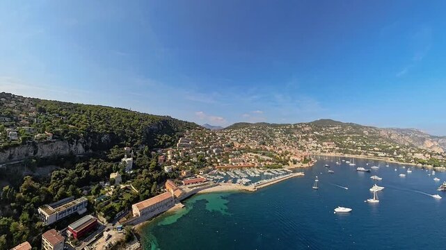 Villefranche-sur-mer bay and harbor, aerial view from airplane at low-altitude, under the summer sun