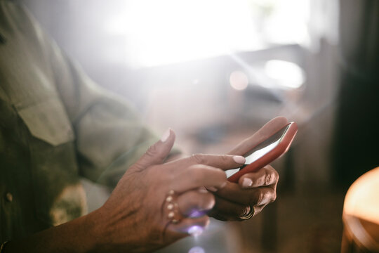 Midsection of woman surfing on smart phone at home