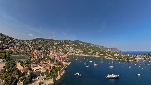 Villefranche-sur-mer bay and harbor, aerial view from airplane at low-altitude, under the summer sun