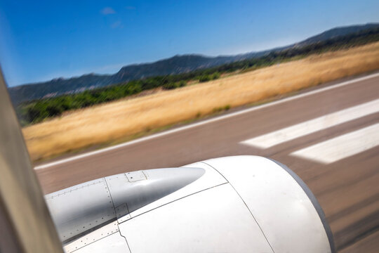 Airplane Lands on Runway Near Green Hills