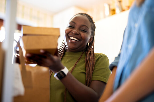 Happy woman holding food parcel box in hand