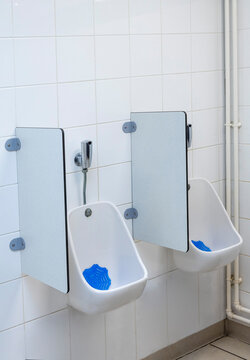 Two Men Stand at Urinals in a Restroom