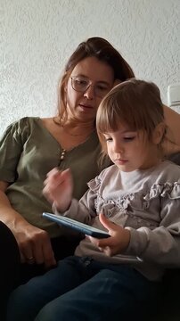 Mother and child spend time together while using a smartphone at home