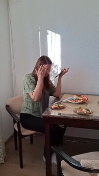 Woman enjoys meal at a table with food in a bright room during the day