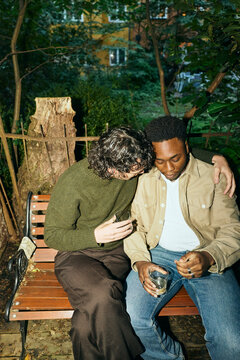 Young man embracing male friend while consoling his feelings at courtyard