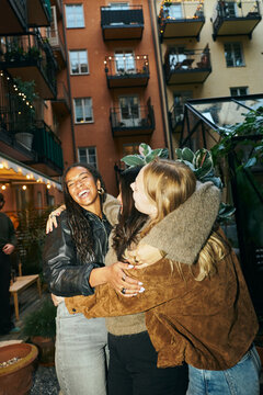 Lovable female friends dancing with each other in courtyard party