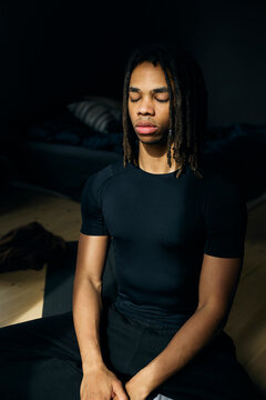 Young man practicing meditation while sitting at home